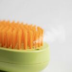 Detalle macro de las púas y el orificio de pulverización del cepillo para mascotas